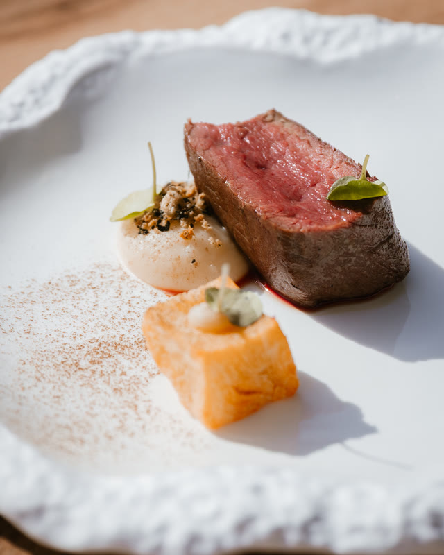 Tournedos van rund met garnituur op een wit bord.