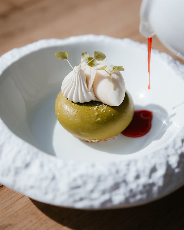 Dessert van pistache en meringue op een wit bord.